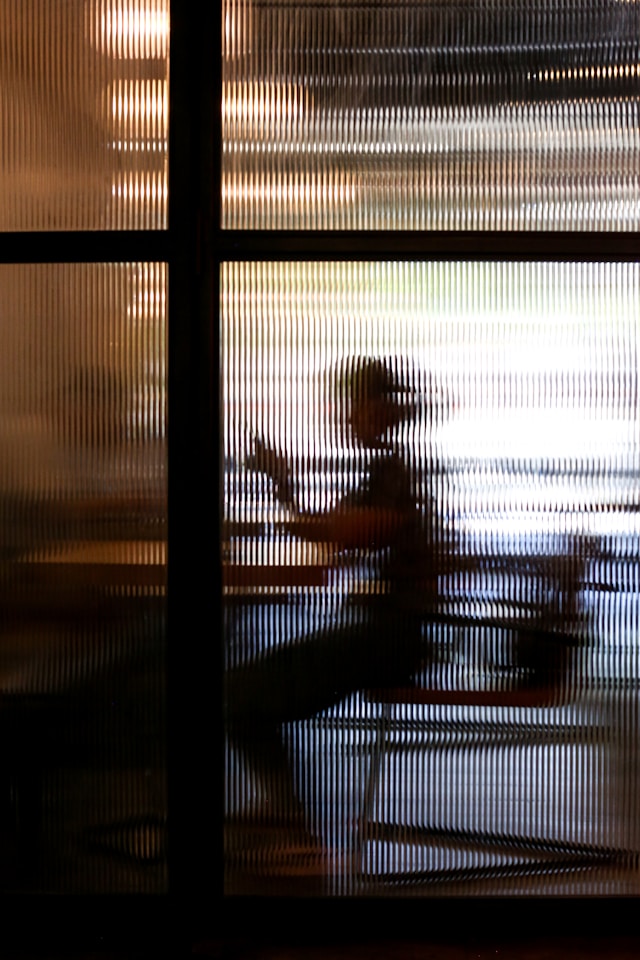 2-people-sitting-on-chair-near-window-during-sunset