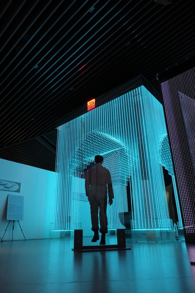 man-in-black-jacket-standing-on-blue-lighted-room